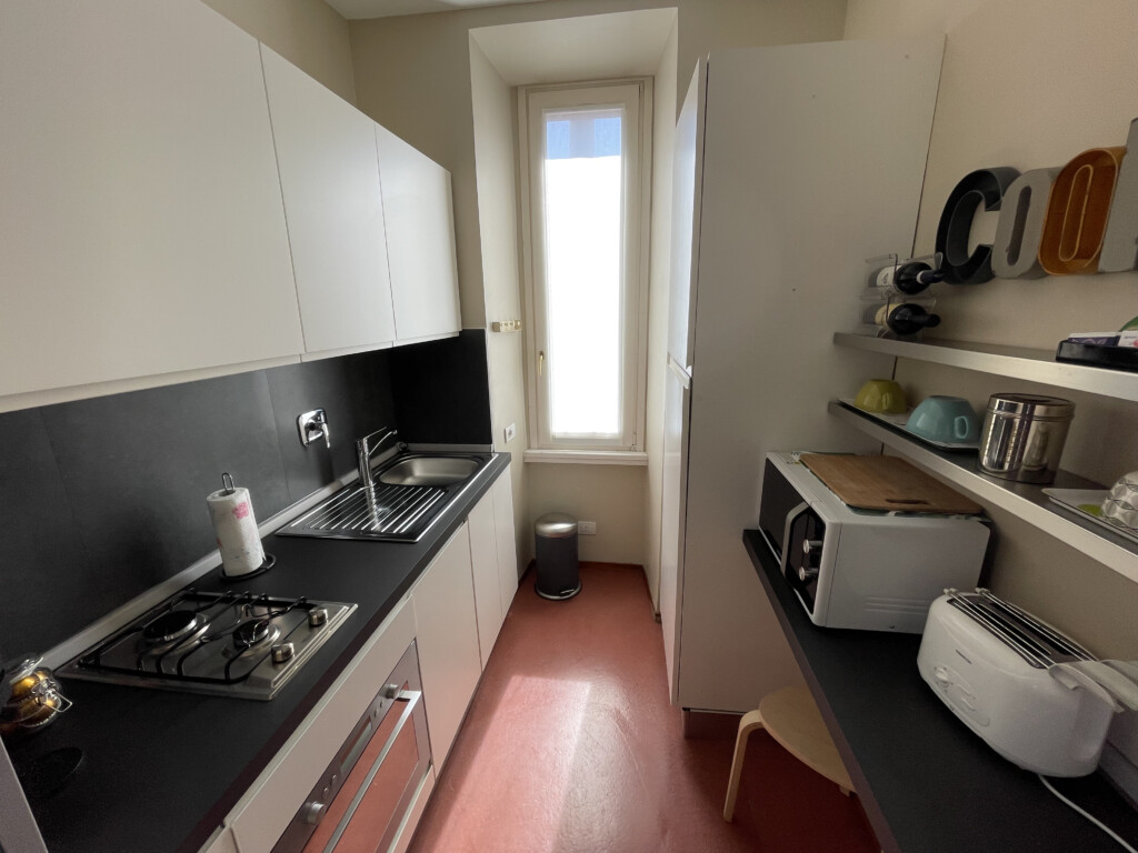 a kitchen with white cabinets and black counter tops