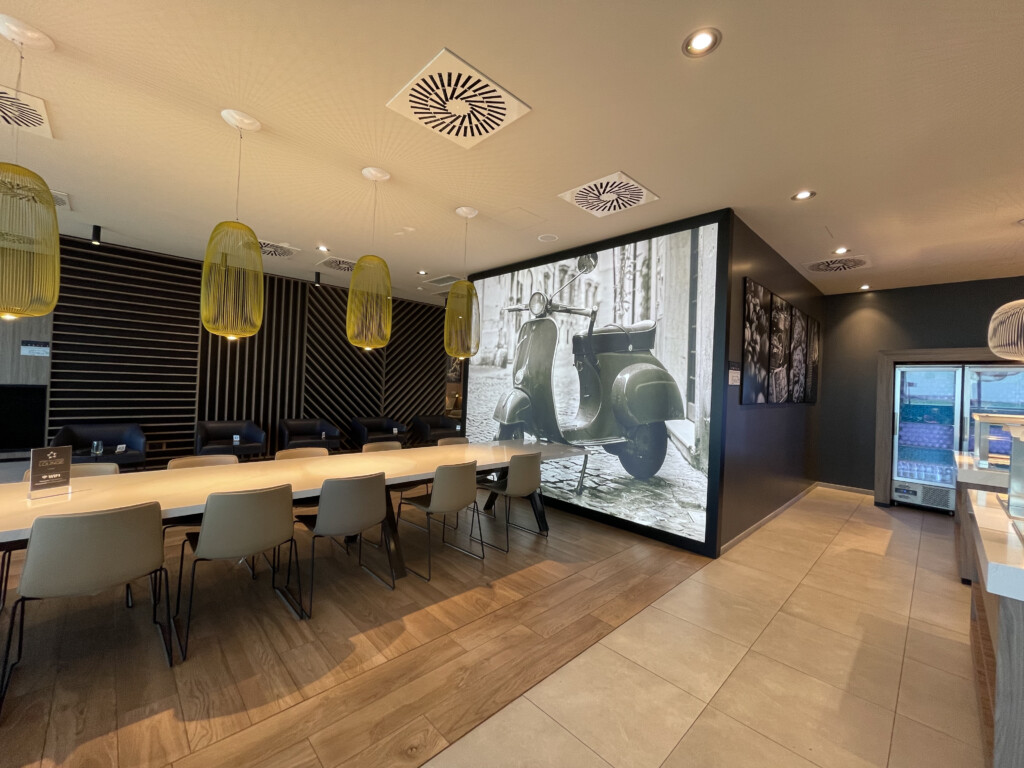 a room with a table and chairs and a large screen