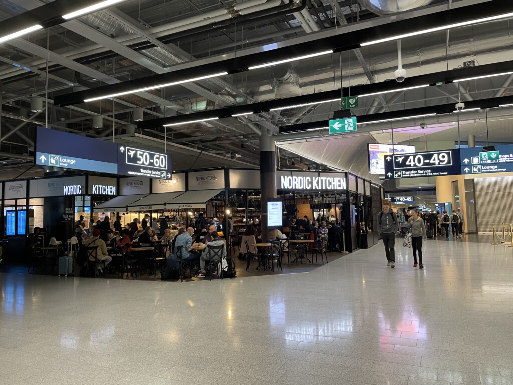 a large airport terminal with people and signs