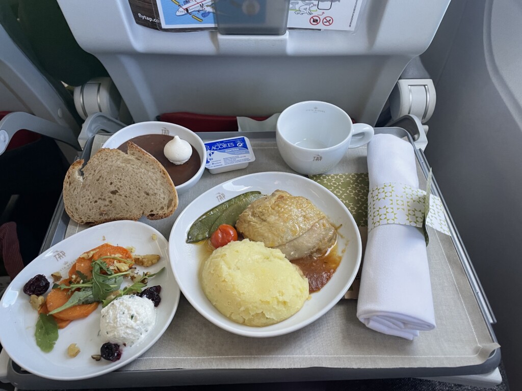 food on a tray with a cup and a plate of food