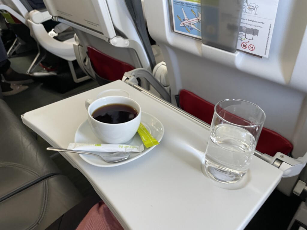 a cup of coffee and a glass of water on a tray