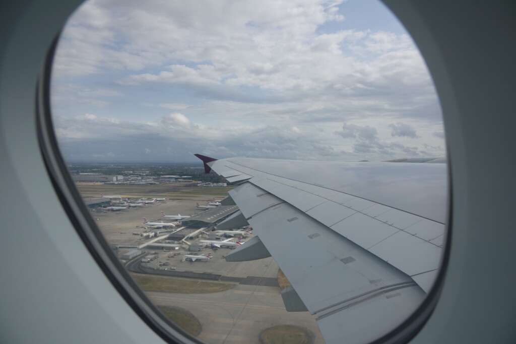 an airplane wing and runway with many airplanes in the background