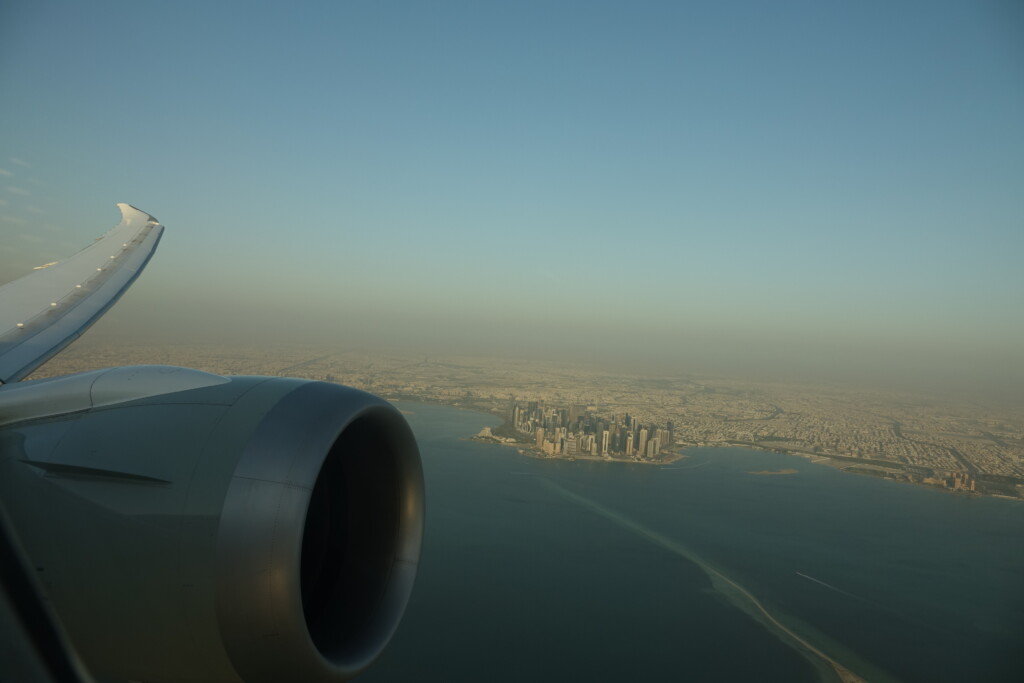 an airplane wing with a city in the background