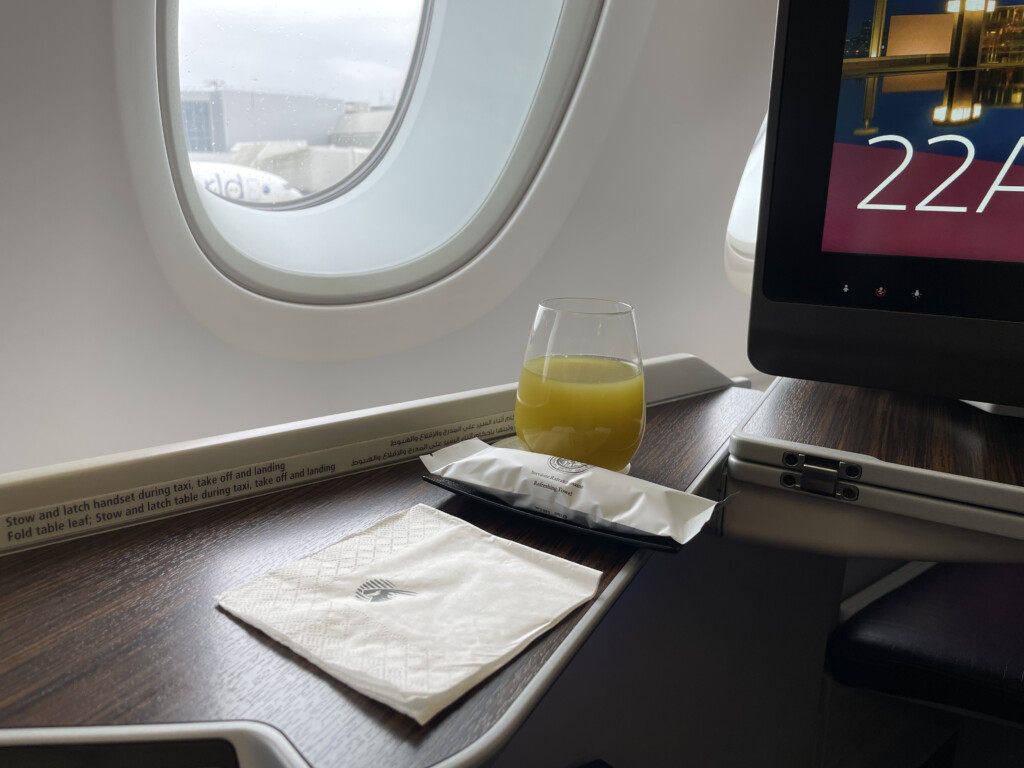 a glass of juice and napkins on a table