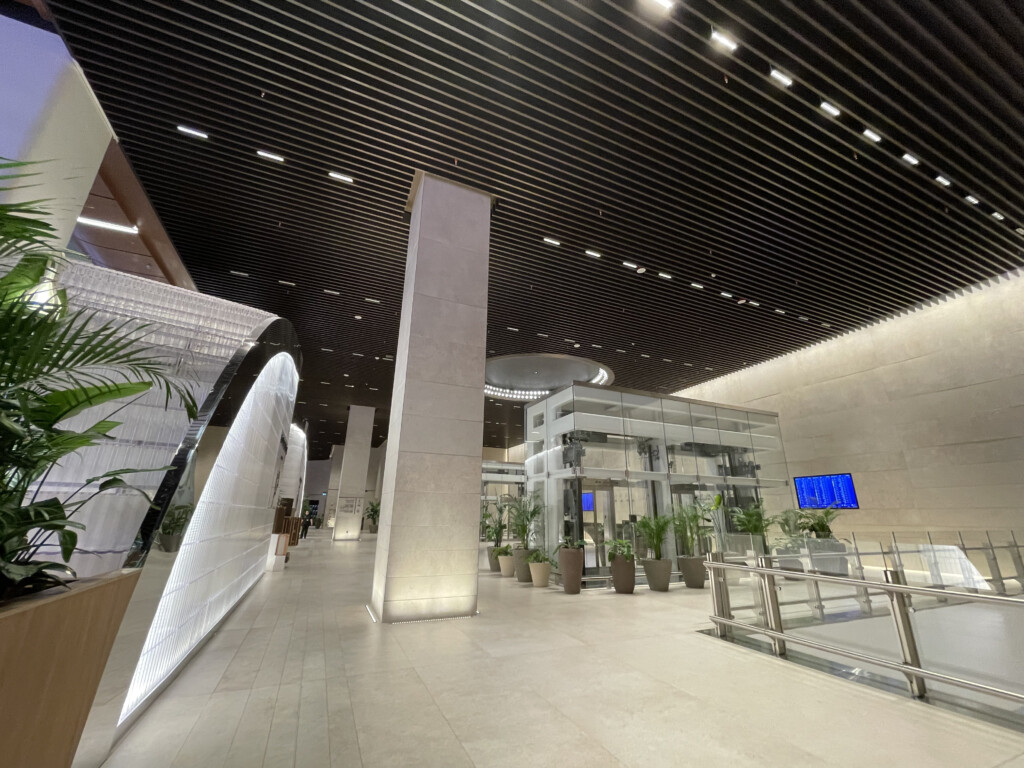 a large building with a glass pillar and plants