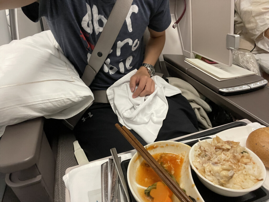 a person sitting in a chair with food on the table