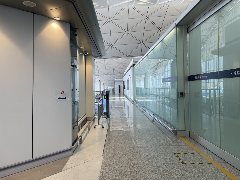 a hallway with glass walls and a white ceiling