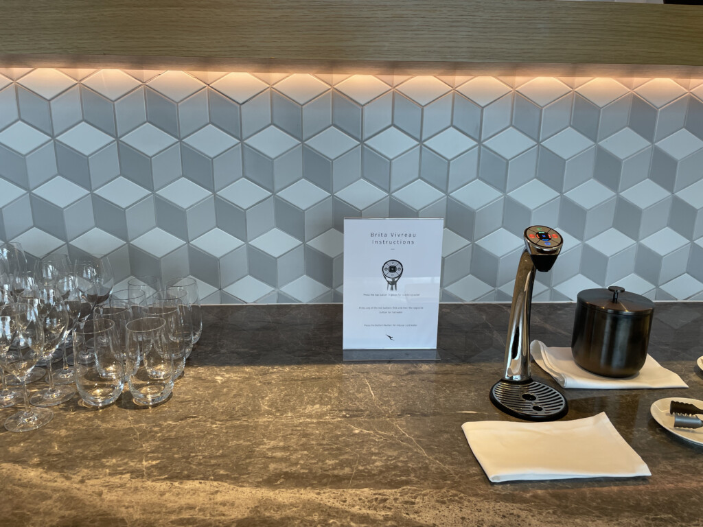 a counter with a faucet and glasses on it