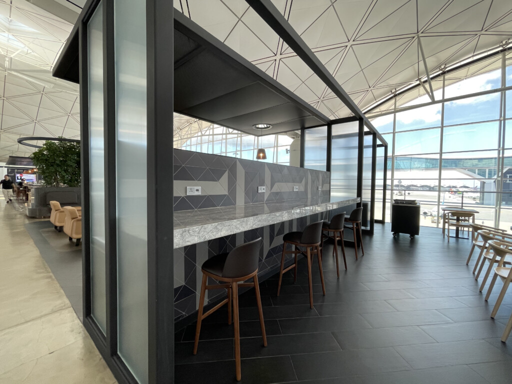 a bar with chairs in a room with a glass wall