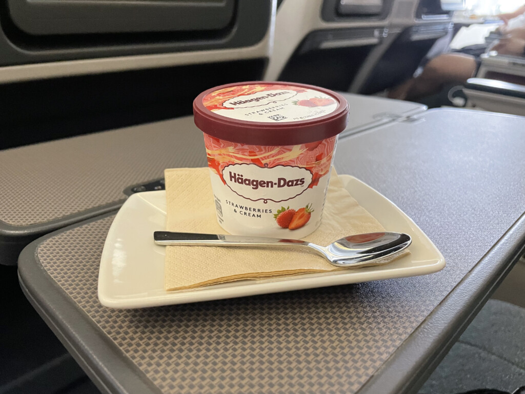 a cup of ice cream on a plate with a spoon