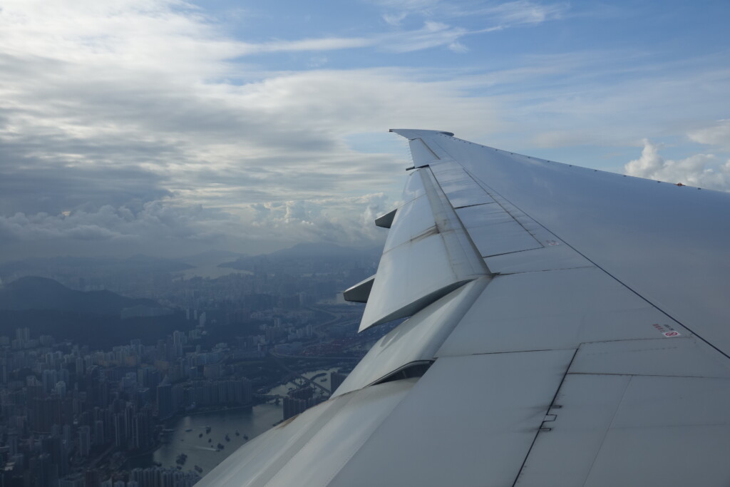 an airplane wing with city in the background