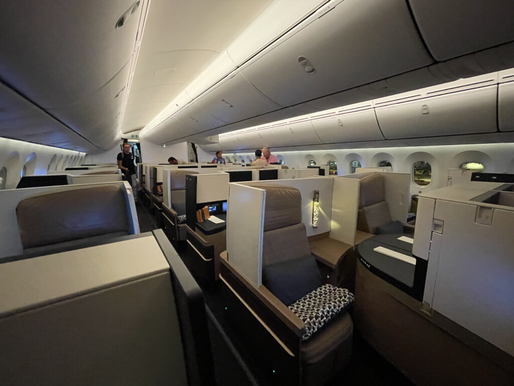 a inside of an airplane with people sitting in chairs