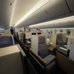 a inside of an airplane with people sitting in chairs