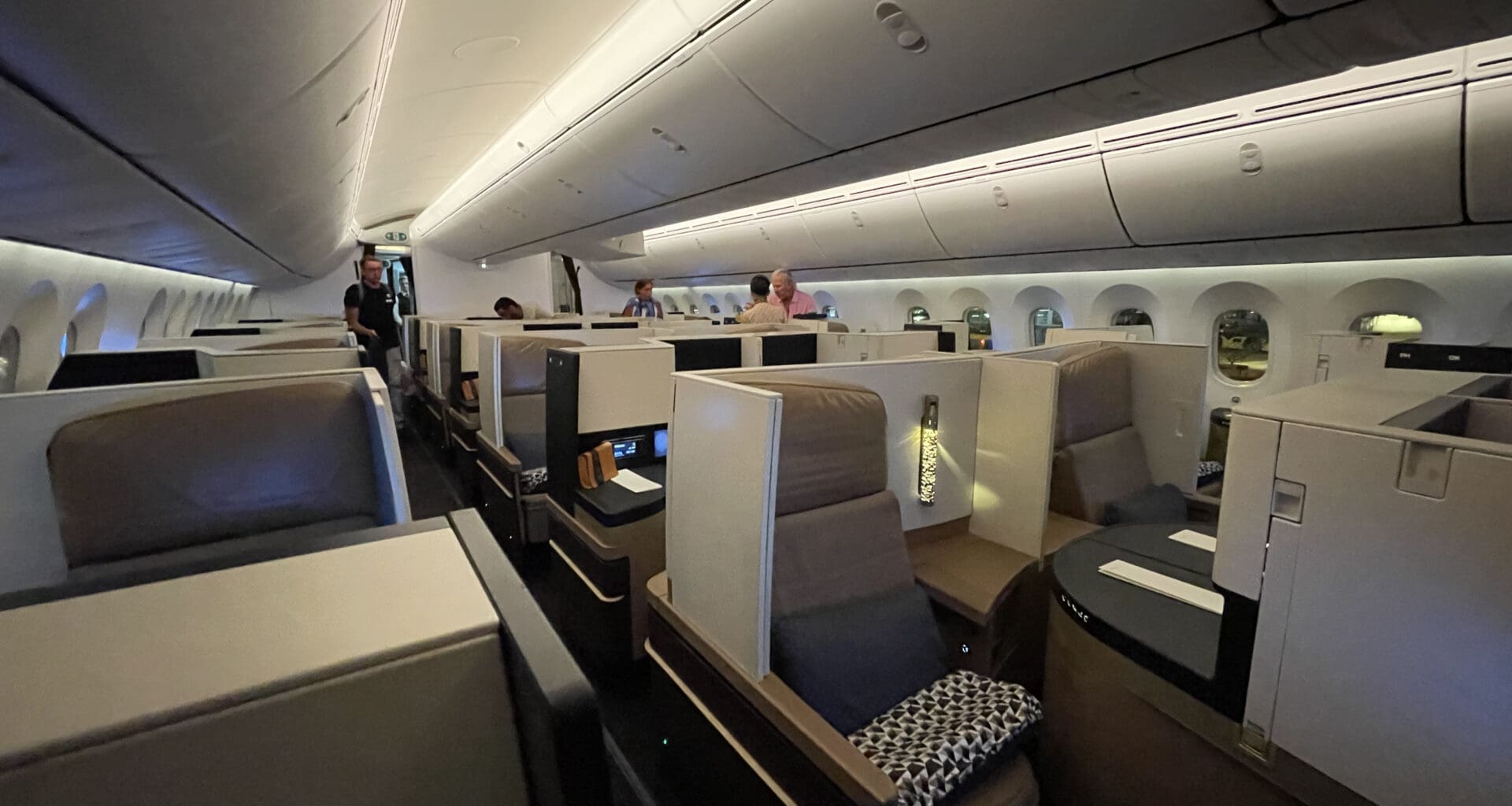 a inside of an airplane with people sitting in chairs