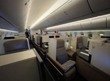 a inside of an airplane with people sitting in chairs