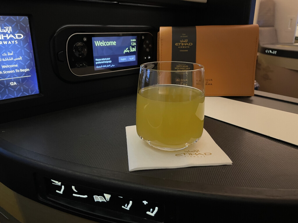 a glass of orange liquid on a napkin on a table