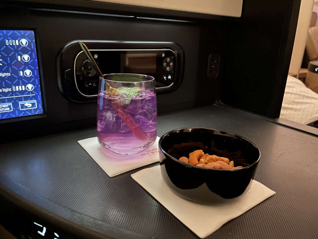 a bowl of nuts and a drink on a table