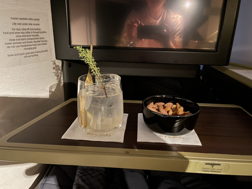 a bowl of nuts and a drink on a table