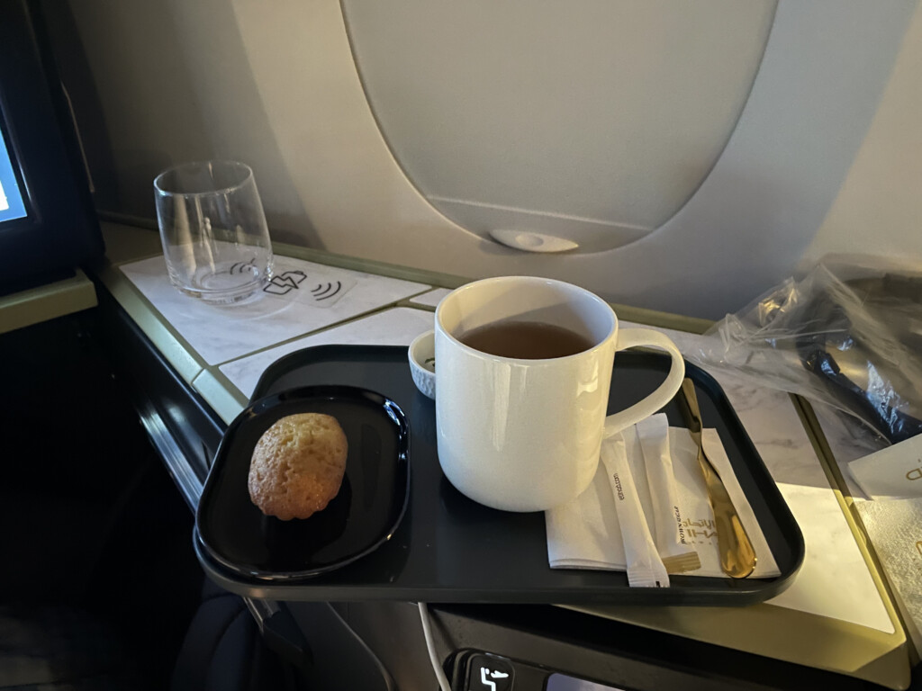 a tray with a cup of tea and a muffin on it