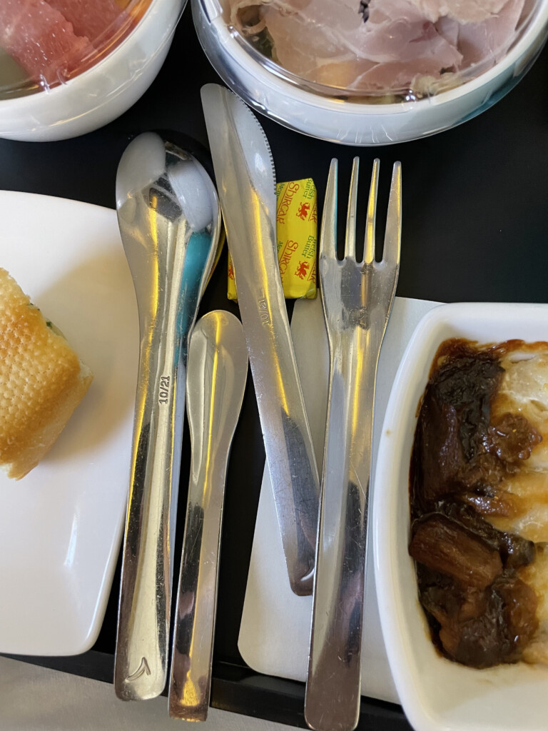 a plate with silverware and a bowl of food