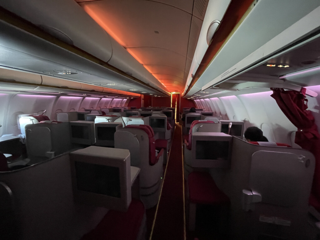 an airplane with seats and a row of monitors