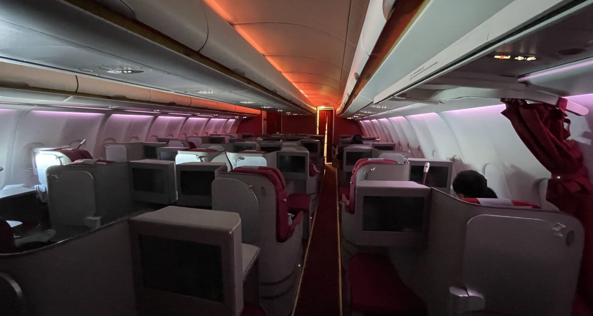 an airplane with seats and a row of monitors