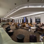 a group of people sitting in a room with chairs and luggage