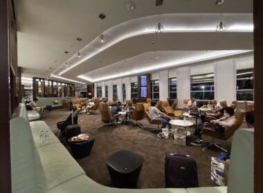 a group of people sitting in a room with chairs and luggage