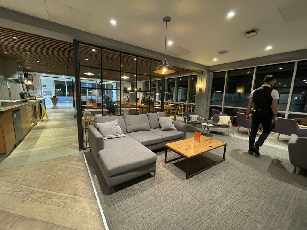 a man walking in a room with a couch and coffee table