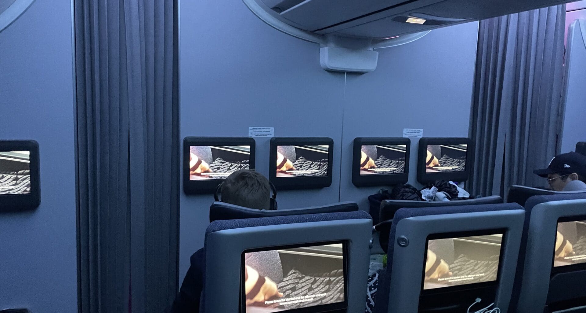 a person sitting in a chair with a few monitors on the wall