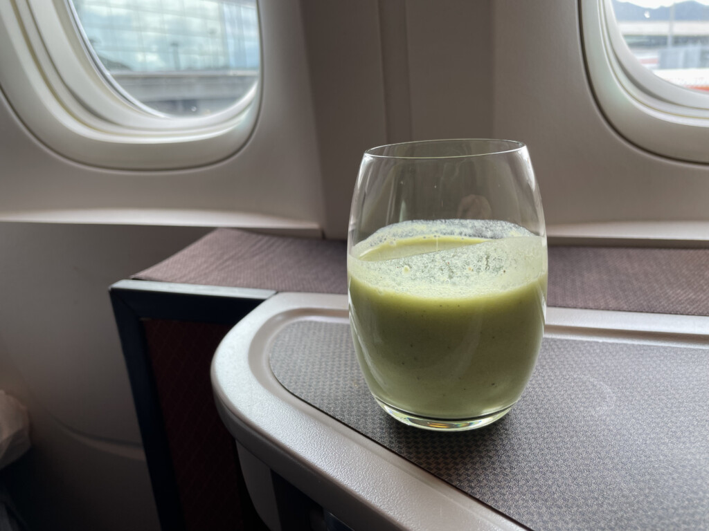 a glass of green liquid on a table