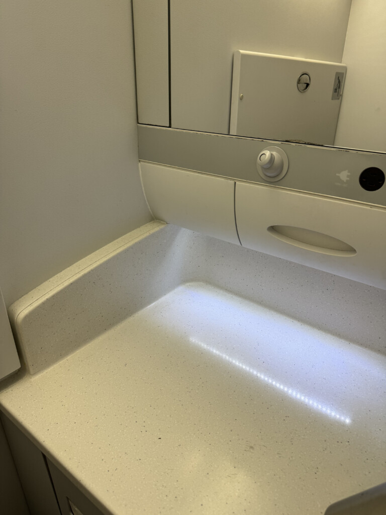 a white counter top with a mirror above it