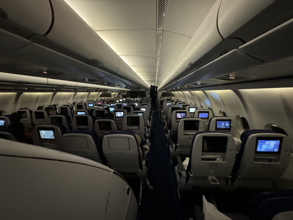 an airplane with rows of seats and monitors