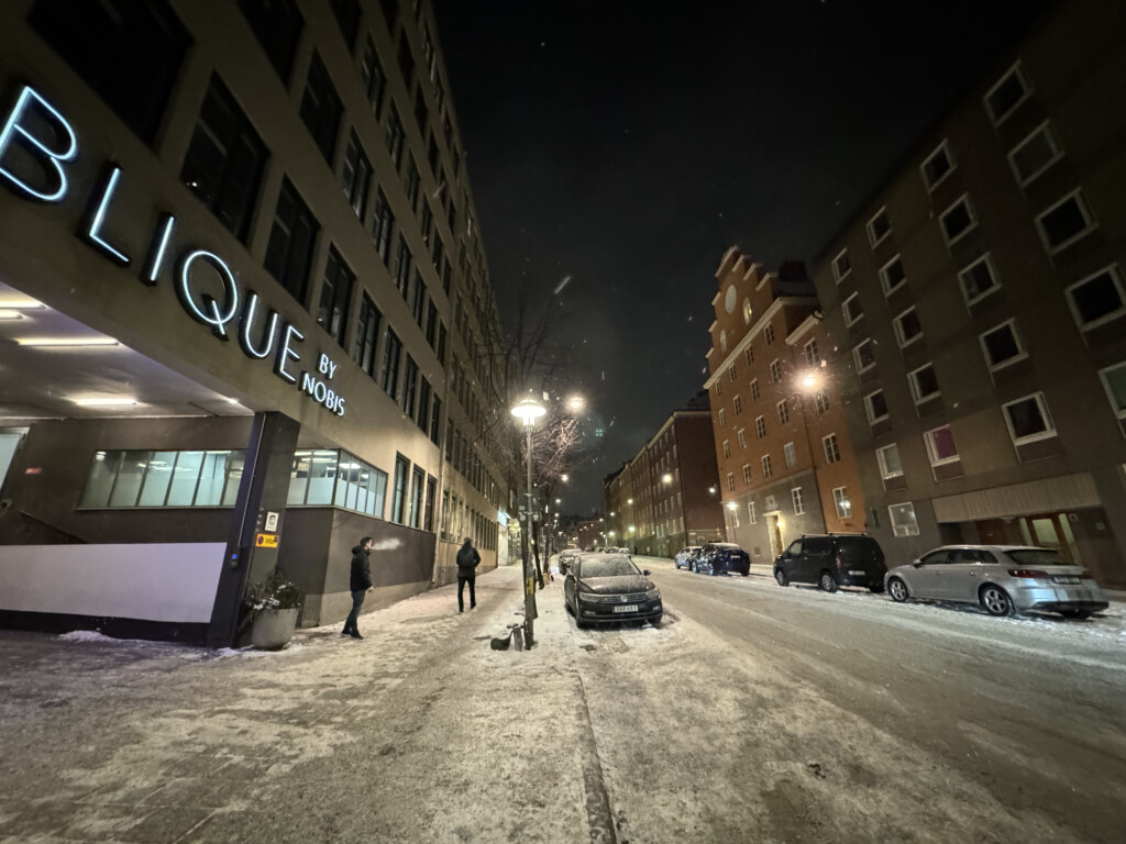 a snowy street with cars and buildings