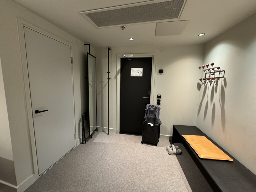 a hallway with a black door and a black bench