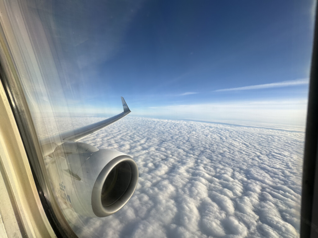 a view of the wing of an airplane above the clouds