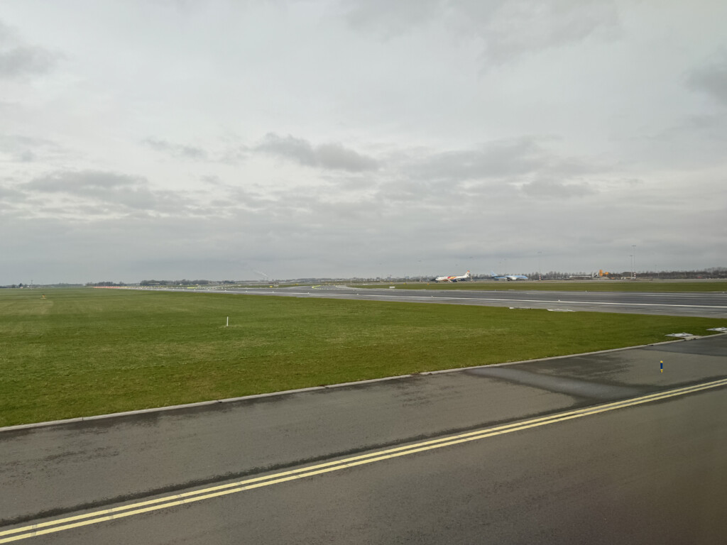 a runway with grass and a road