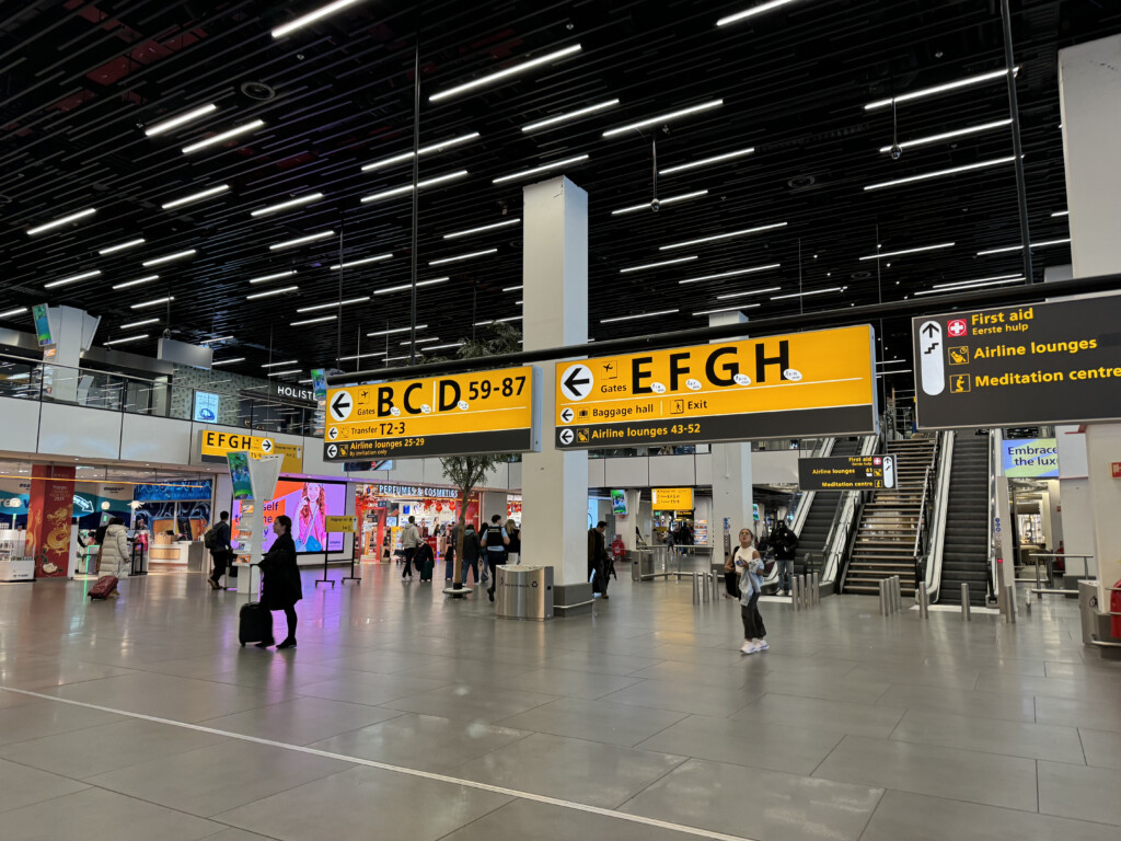 a large airport terminal with people walking and luggage