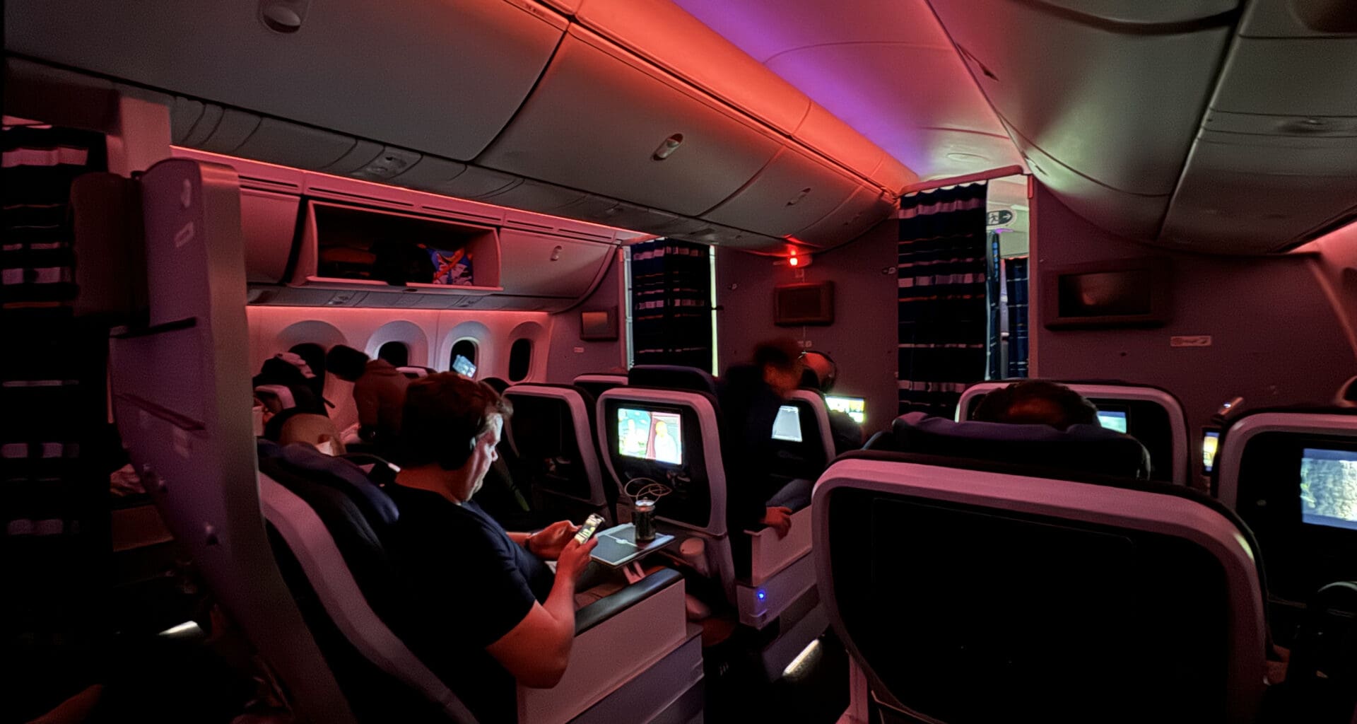 people sitting in an airplane with a group of people in the back