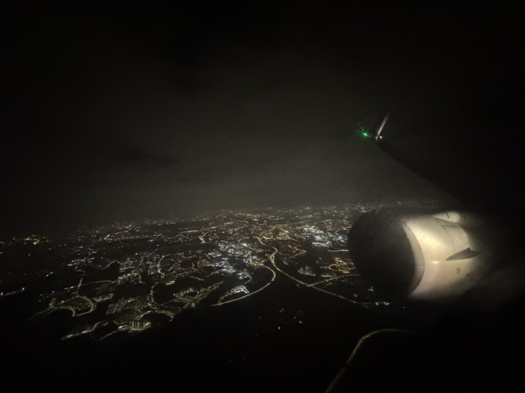 an airplane wing and a city at night