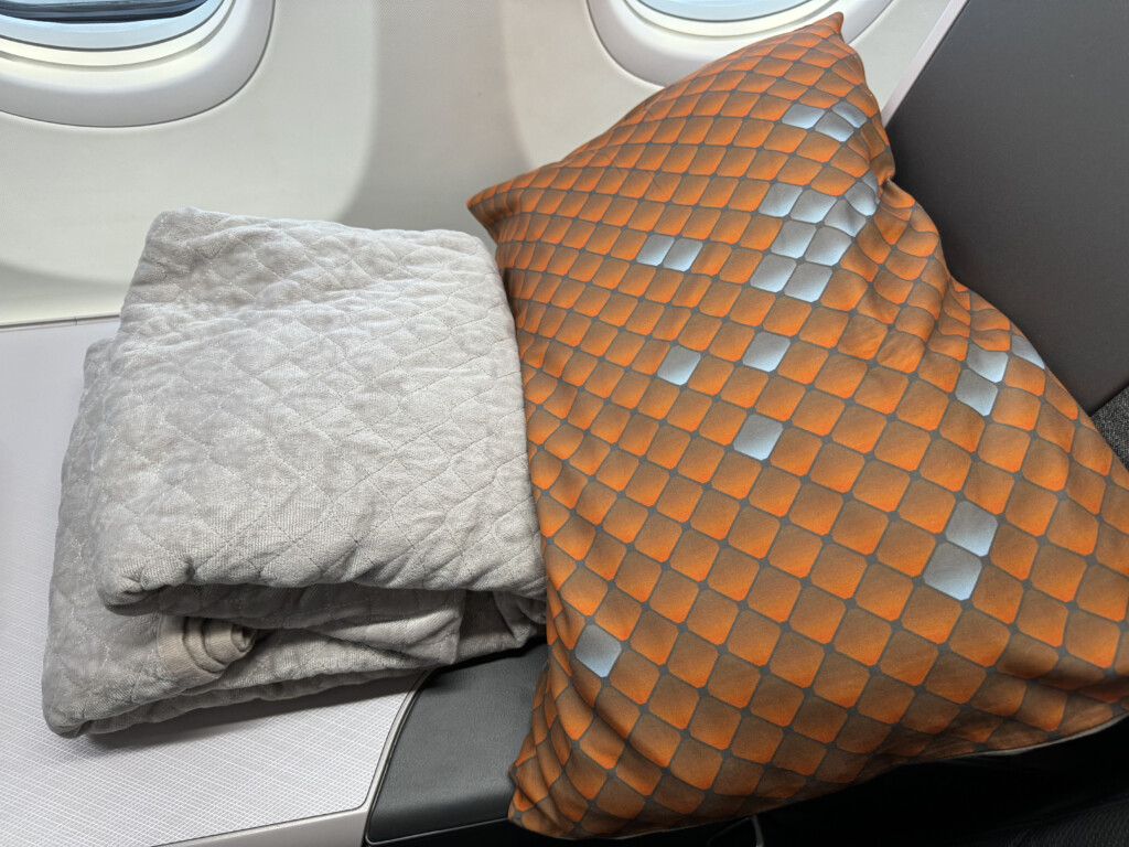 a pillow and blanket on a seat