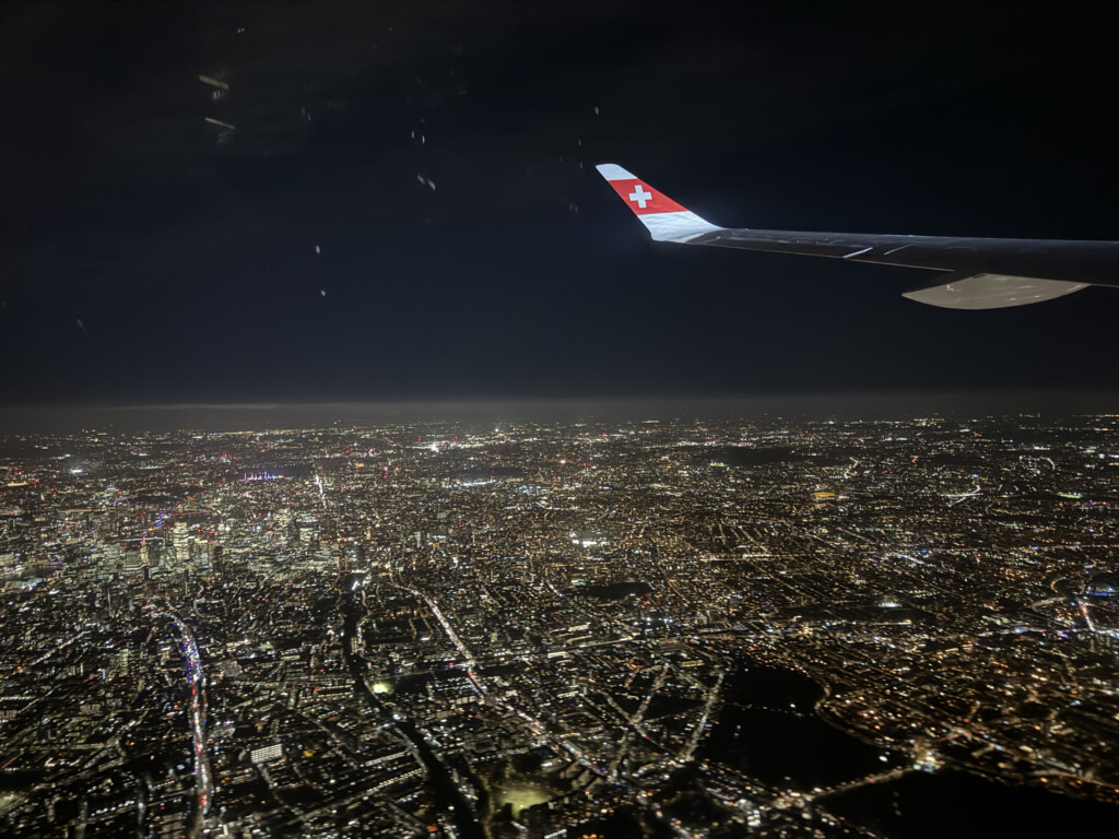 an airplane wing in the sky above a city