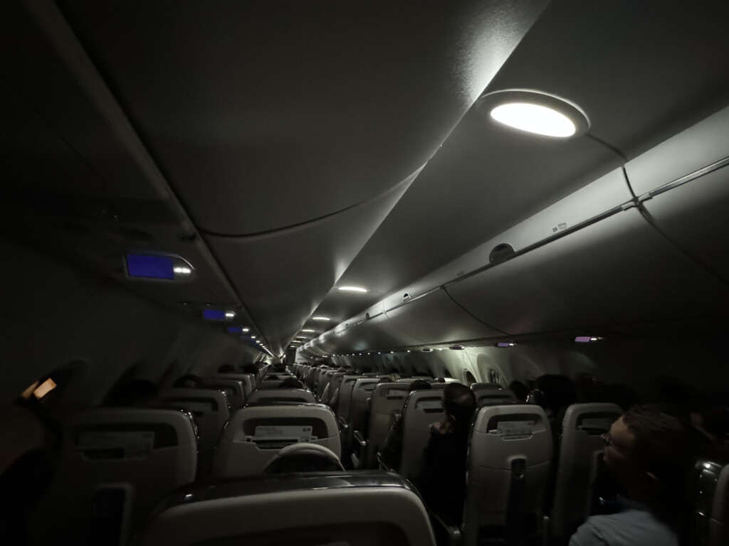 a plane with people sitting in the aisle
