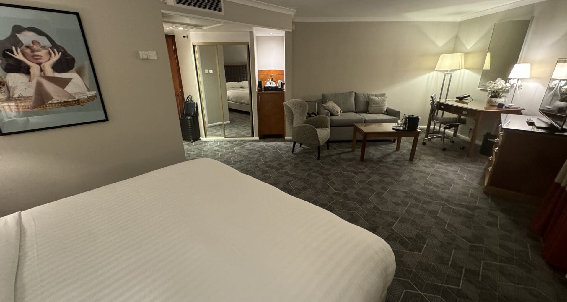 a room with a bed and a couch and a lamp