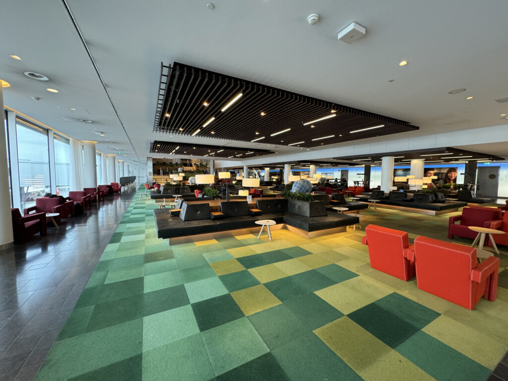 a large room with green and red chairs and tables