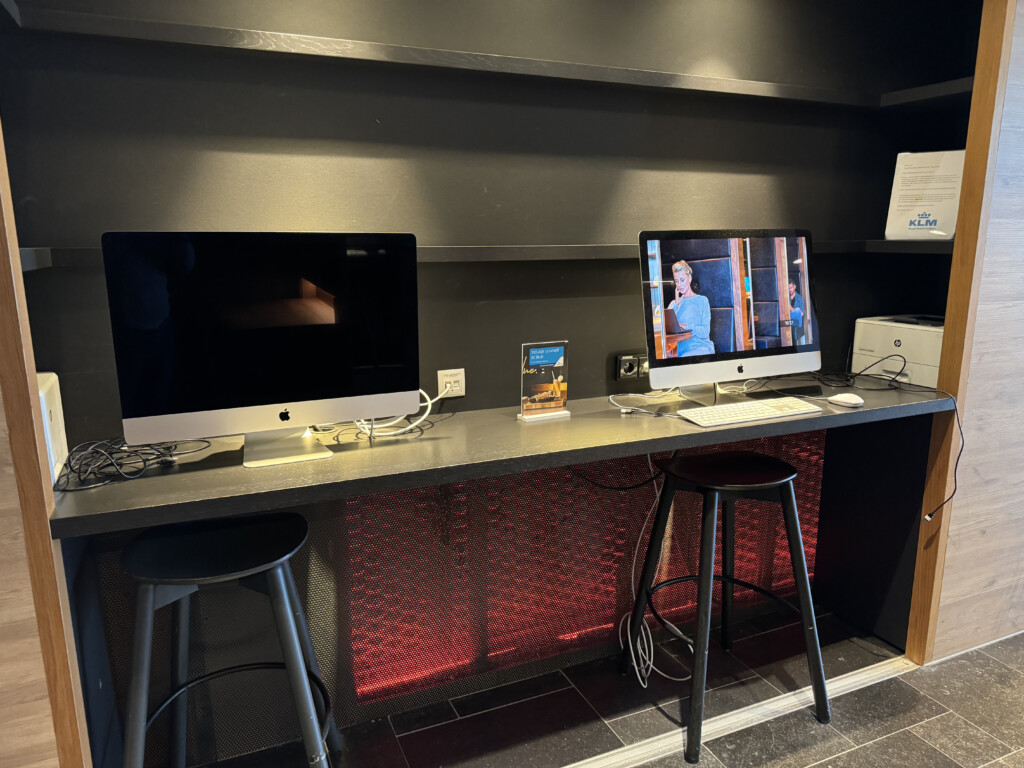 a desk with a computer and a bar stool