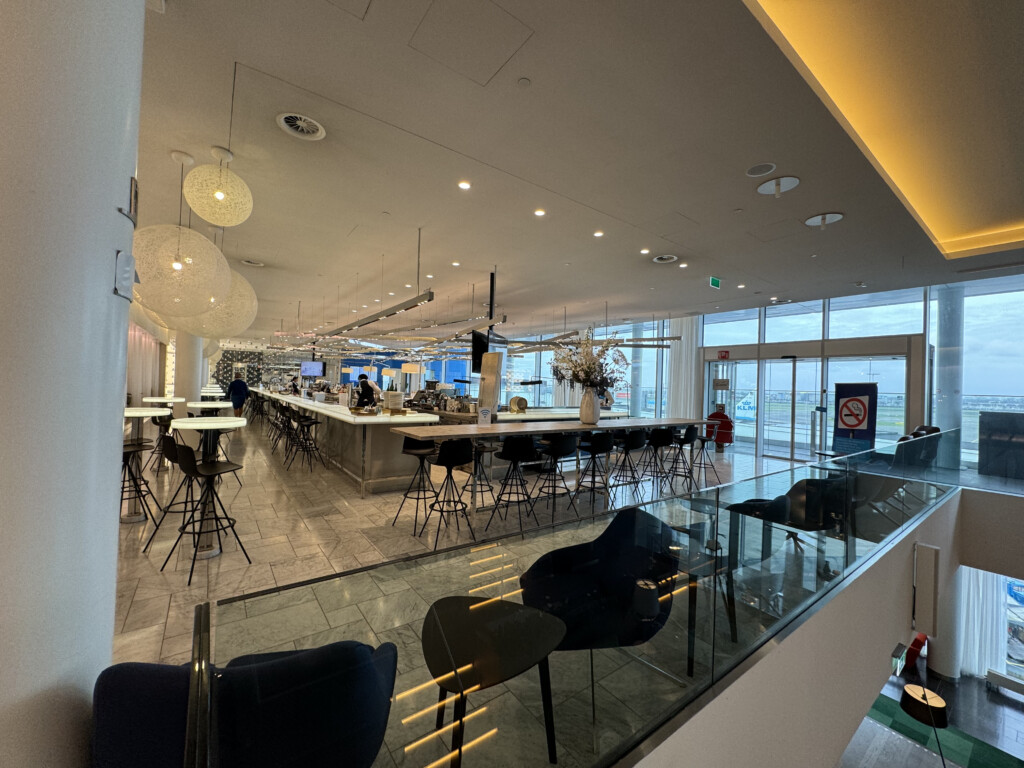 a glass wall with a bar and chairs