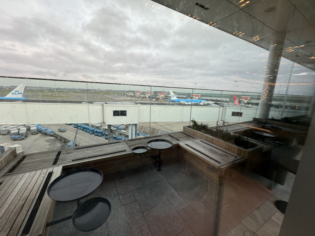 a glass wall with a table and chairs in front of a building