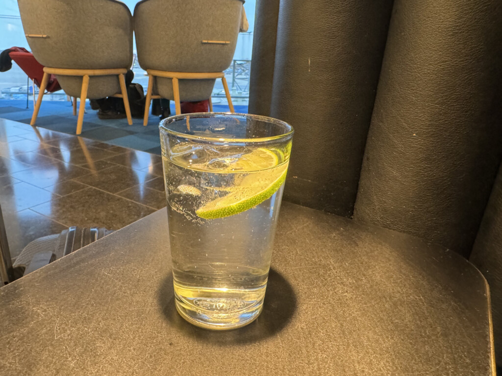 a glass of water with a slice of lime on a table