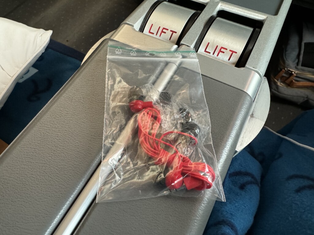 a plastic bag with earbuds on top of a seat